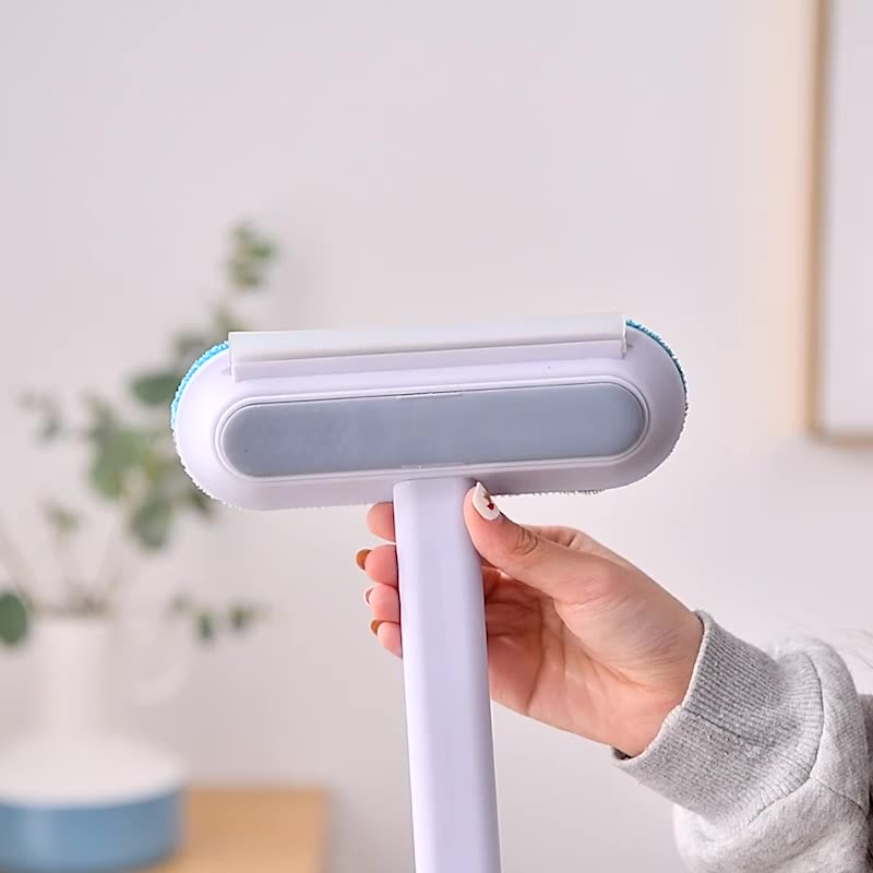 Handheld view of the flannel cleaning head and plastic handle of the pet hair removal brush.